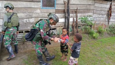 Bagi Susu Kepada Warga Kuari, Satgas Marinir Disambut Gembira